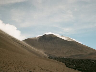 A smoking volcano under a cloudy sky