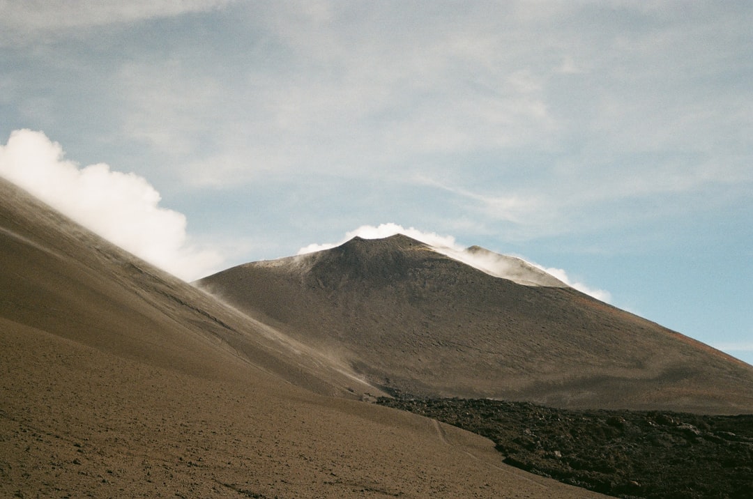 A smoking volcano under a cloudy sky